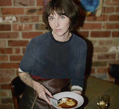 Zoe Birch seated at a table with  her meringue, parsnip and apple dish