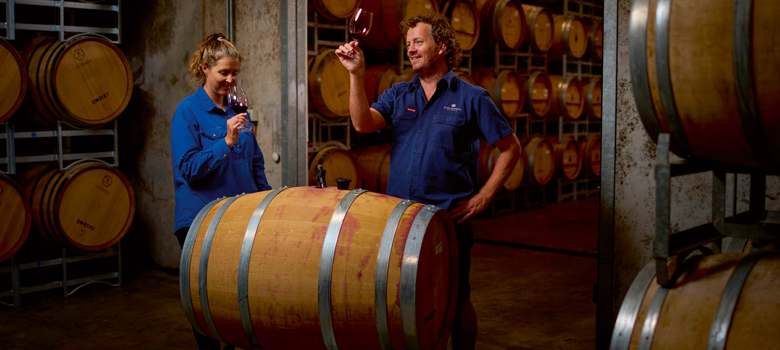 Dalwhinnie winemakers enjoy a glass of Eagle Shiraz in a barrel room