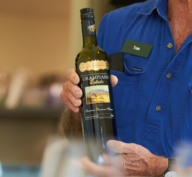 A man holds a bottle of award-winning wine by Grampians Estate