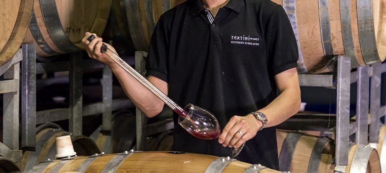 Woman amongst wine barrels at Tertini cellar door in the Southern Highlands