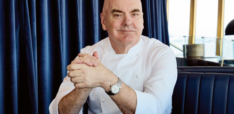 Chef Mark Best seated at Infinity by Mark Best against a backdrop of blue curtains, for Selector Magazine