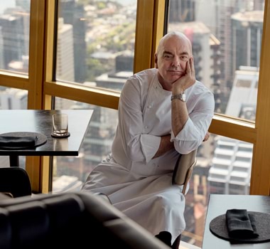 Mark Best seated before the Sydney skyline views of Infinity by Mark Best