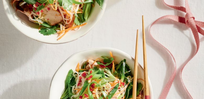 A bowl on a table with chopsticks featuring Lyndey Milan's Vietnamese-style cold noodle bowl recipe with roast pork and nuoc cham