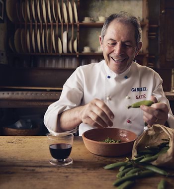 Gabriel Gaté at his dining table shelling peas