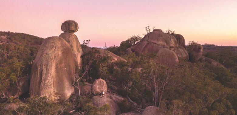 A couple stands before a stunning vista in Girraween National Park in the Granite Belt region.