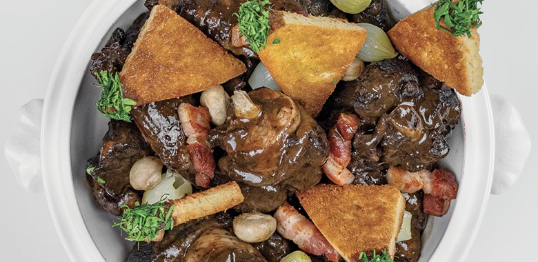 French chef Guy Savoy's coq au vin recipe in a white serving bowl