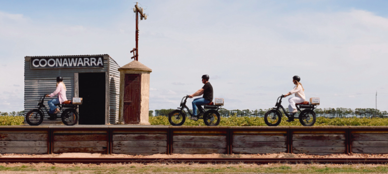 Cyclists riding past the famous Coonawarra Station sign