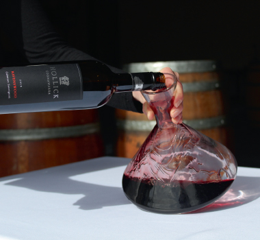 A bottle of Hollick red being poured into a carafe in the Hollick barrel room.