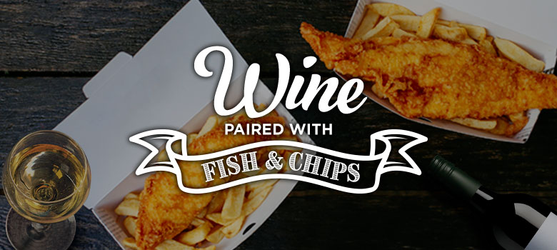 A glass of white wine with takeaway fish and chips